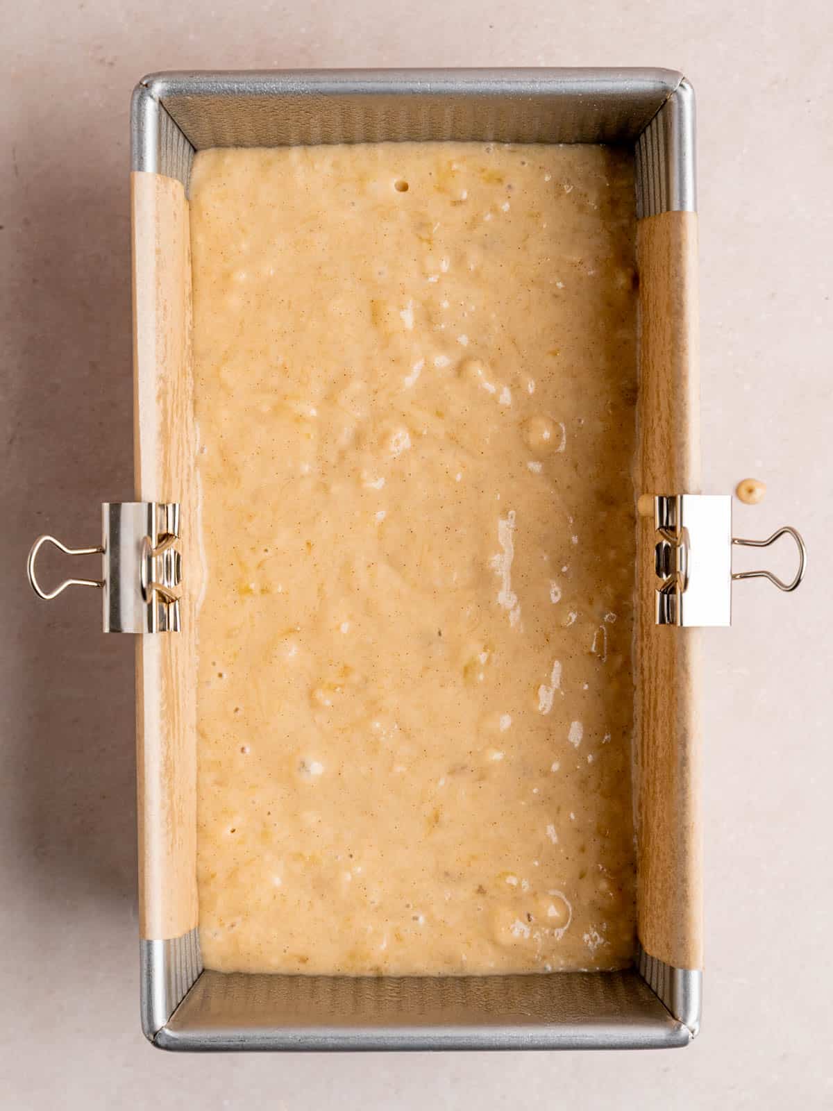 A 9x5 inch loaf pan filled with banana bread batter.