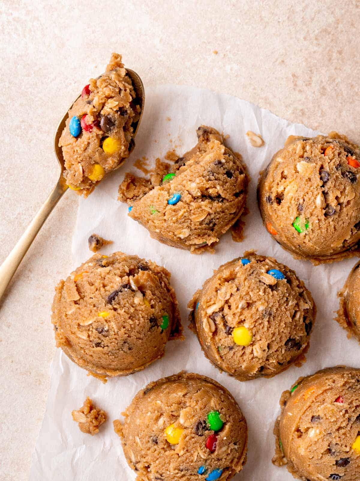 Scoops of edible monster cookie dough on parchment paper.