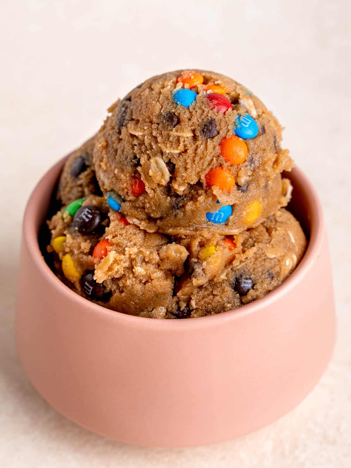 Scoops of edible cookie dough in a pink bowl.