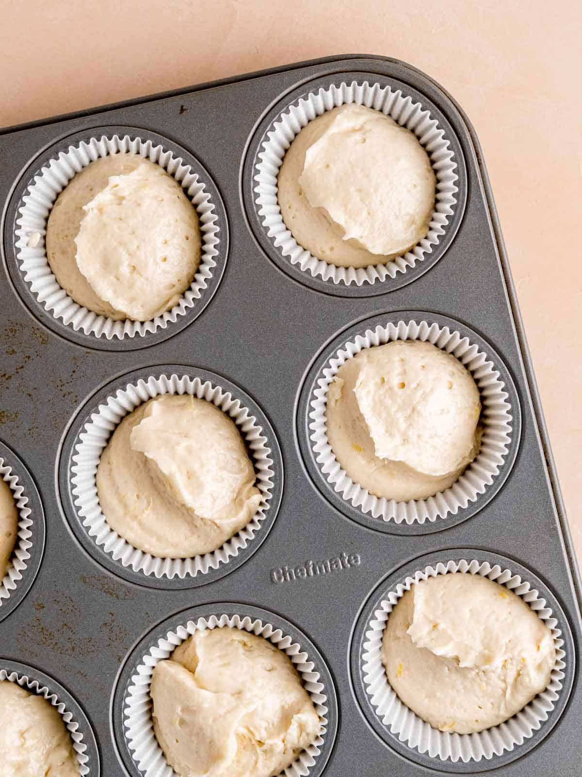 cupcake paper molds filled with dough ready to put in the oven