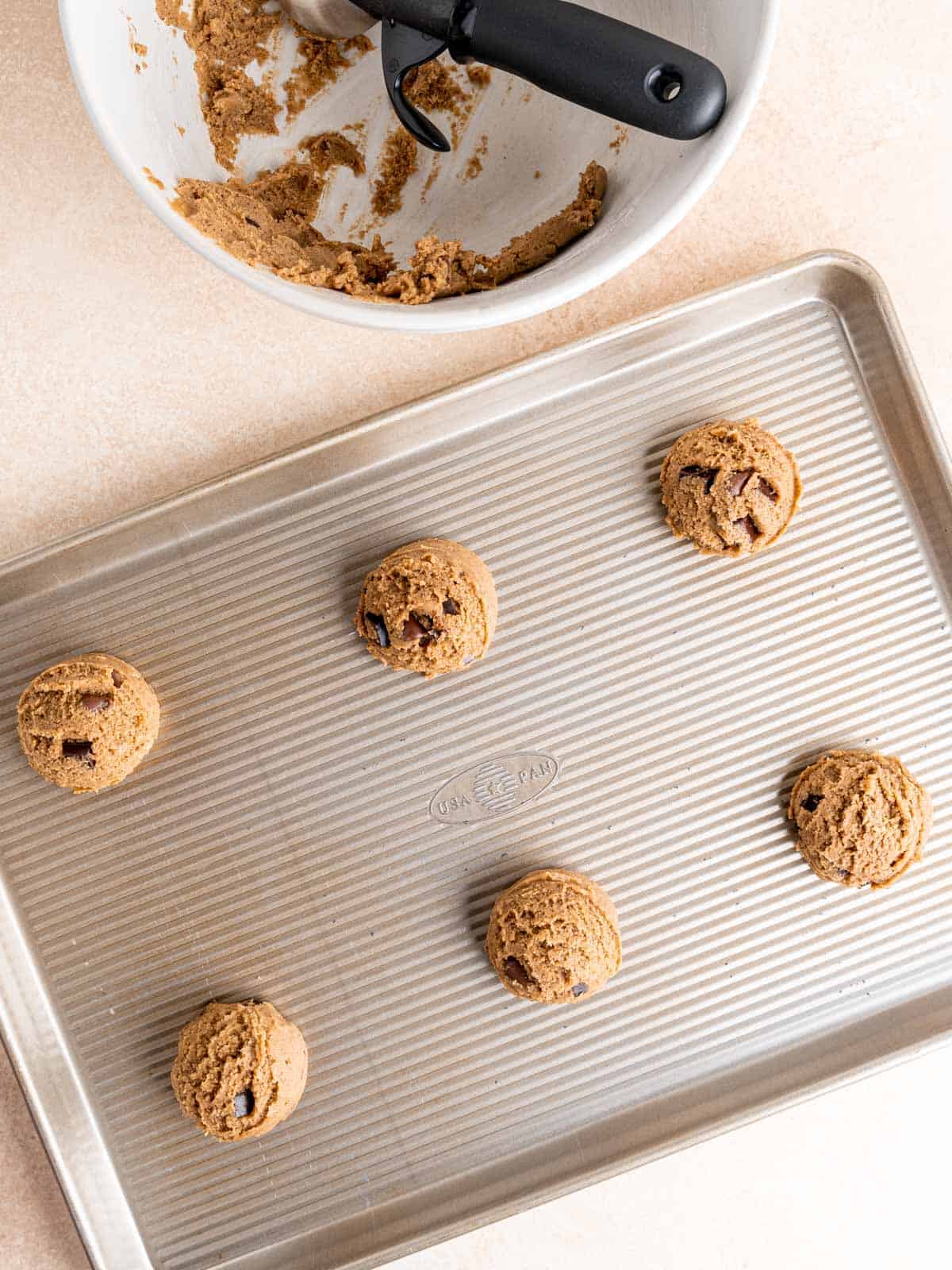 Chocolate chip espresso cookie dough balls on a baking sheet.