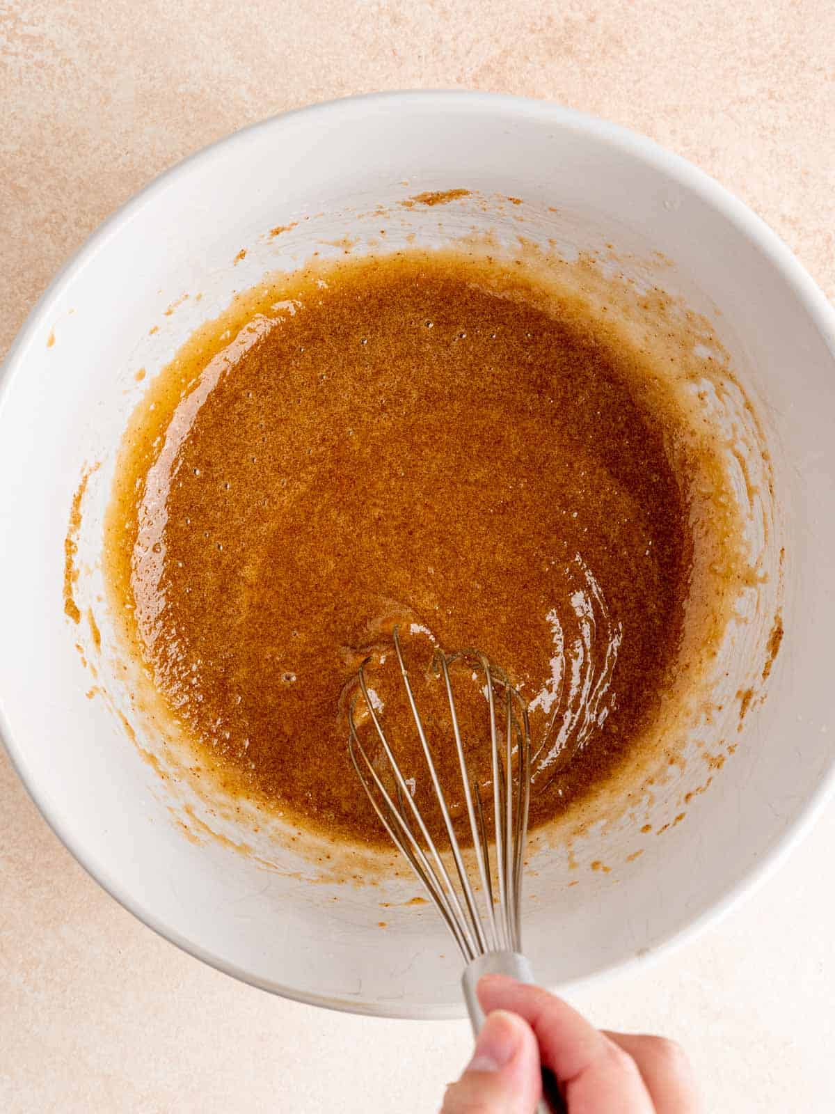 Whisking brown butter, brown sugar, eggs, and vanilla extract in a bowl.