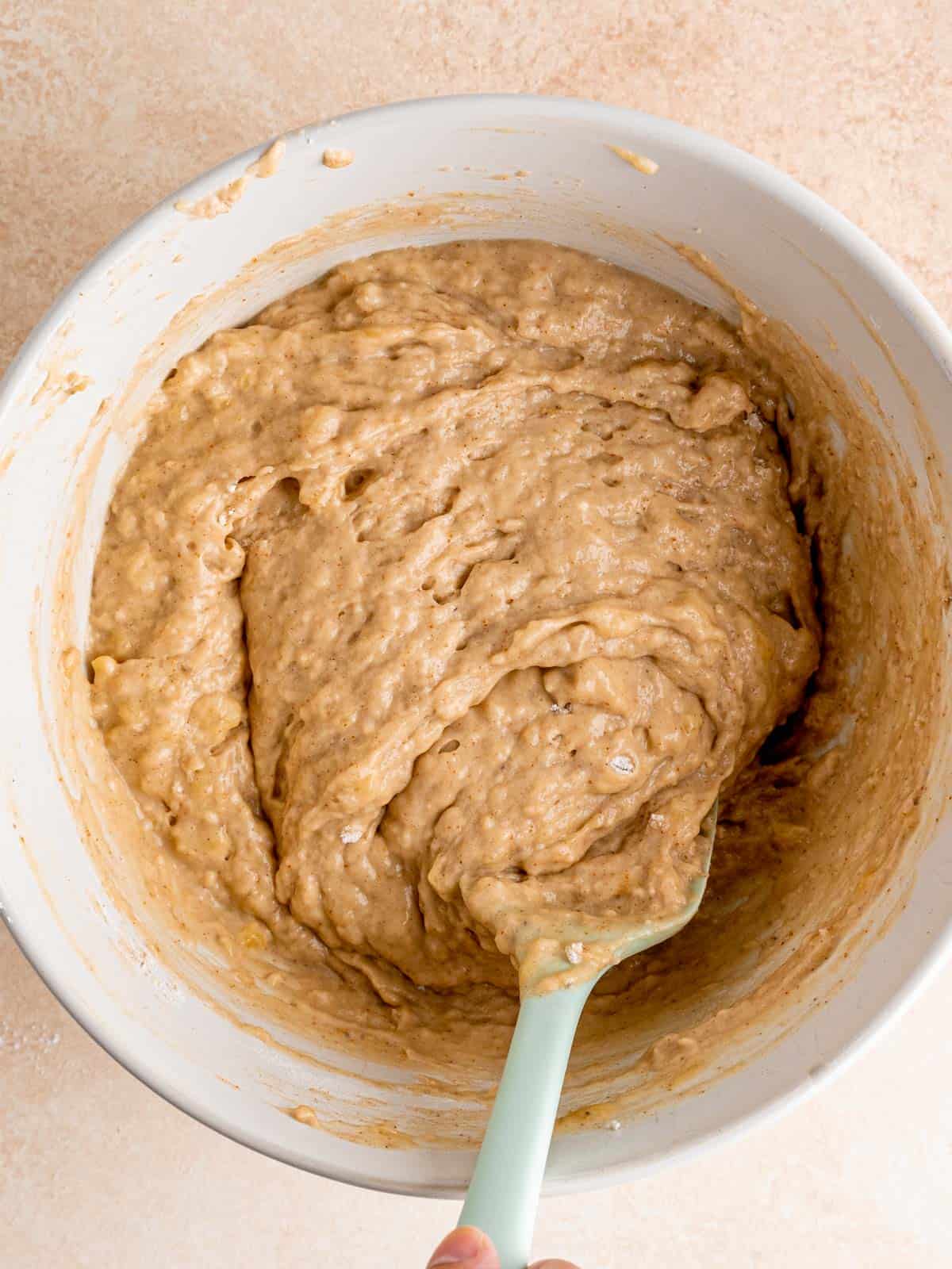Folding dry ingredients into sourdough banana bread batter.