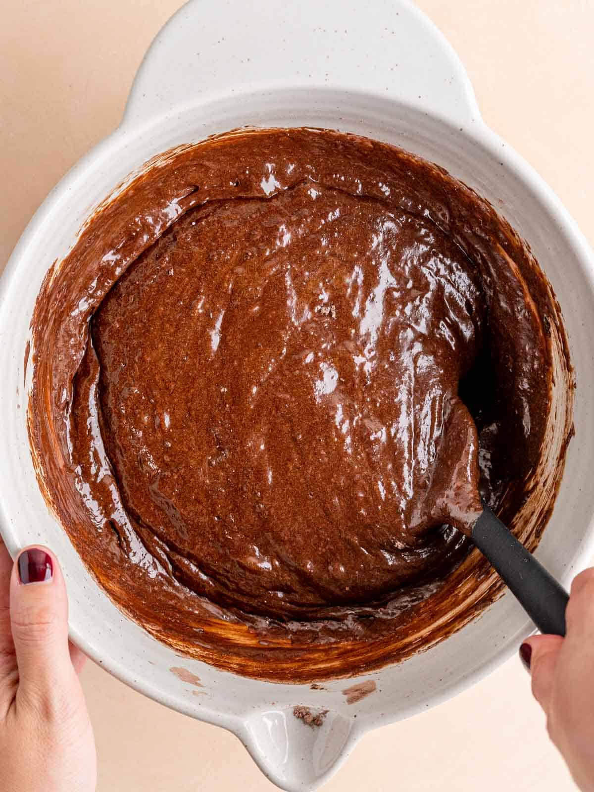 Folding sourdough brownie batter in a bowl.