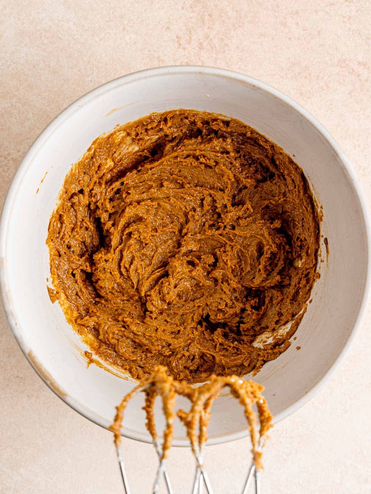 Butter, brown sugar, molasses, and an egg yolk mixed together in a bowl.