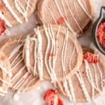 Strawberry shortbread cookies with white chocolate drizzled on top.