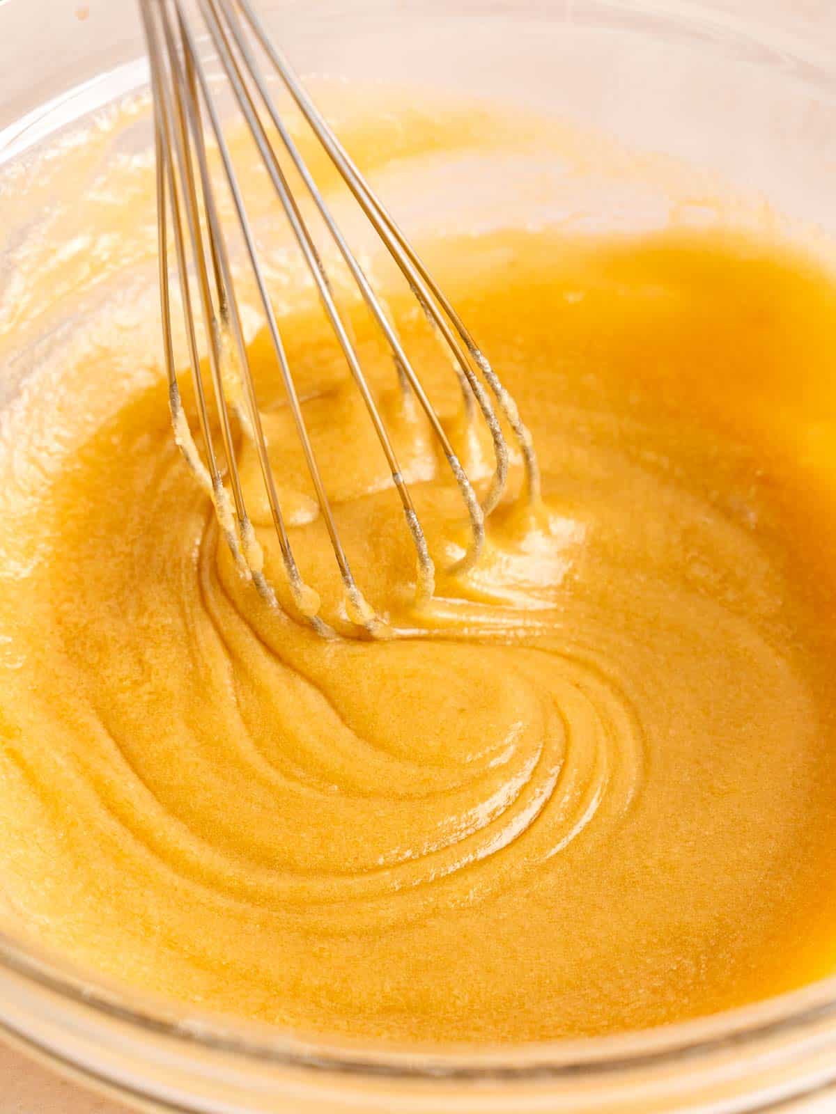 Mixing melted butter, sugars, egg, and vanilla extract in a bowl.