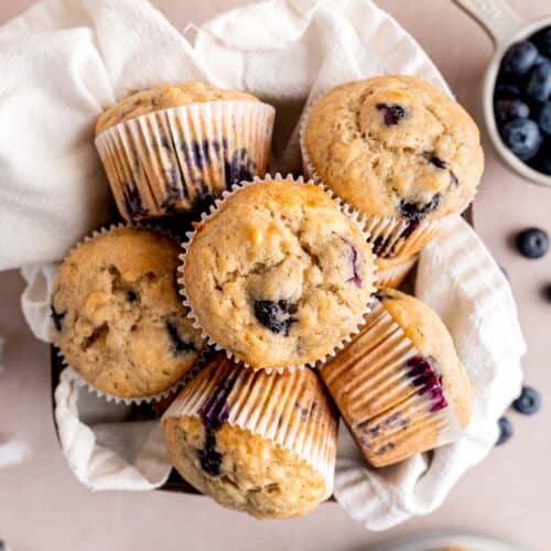 Blueberry banana muffins in a basket with a towel.