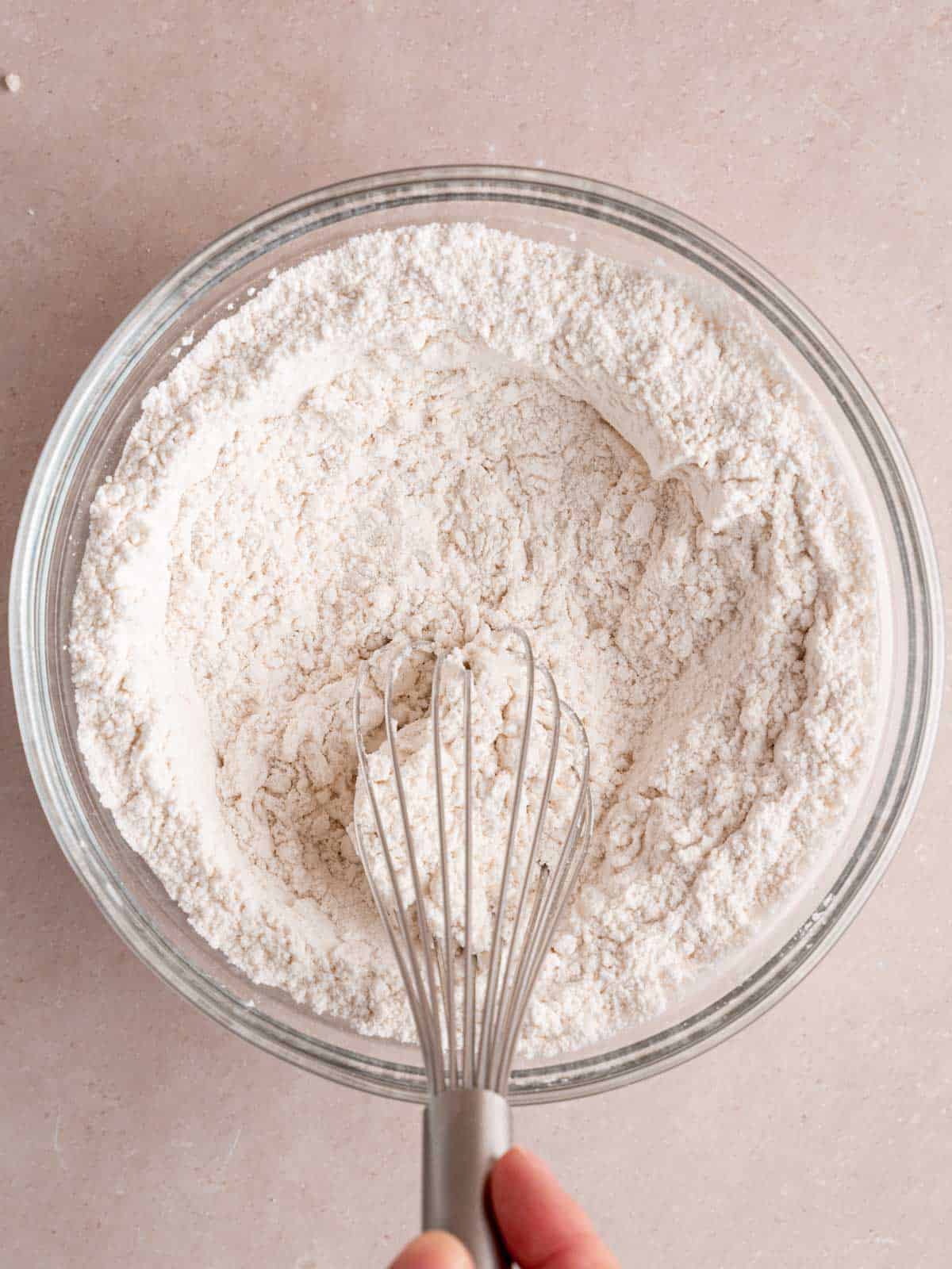 Whisking flour, baking soda, and salt in a bowl.