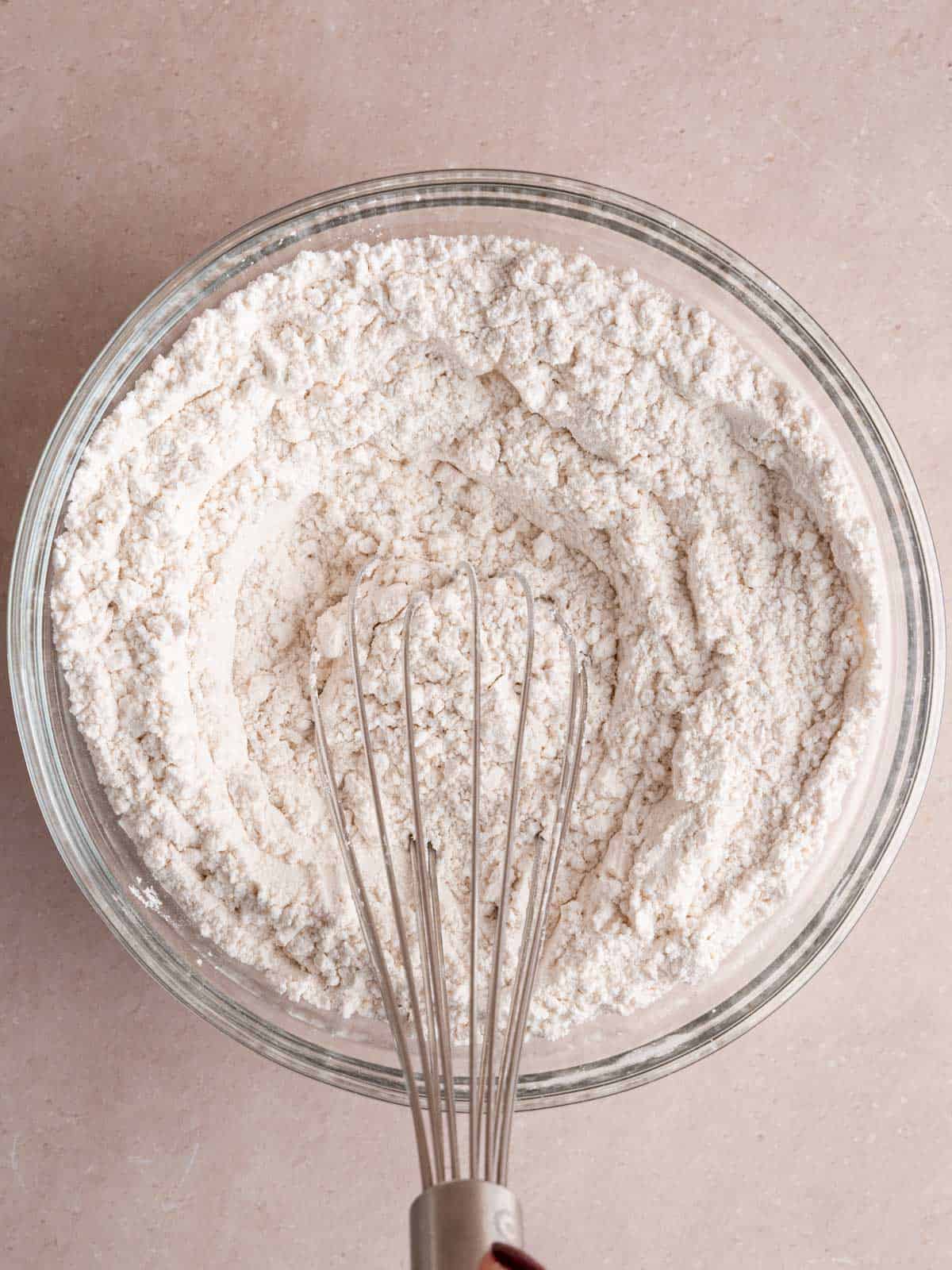 Whisking flour, baking soda, and salt in a bowl.