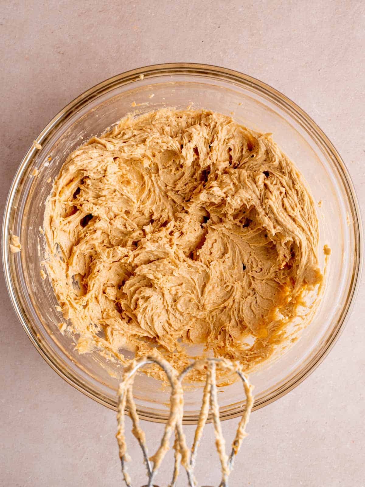 Butter, cookie butter, brown sugar, granulated sugar, egg, and vanilla extract mixed together in a bowl.
