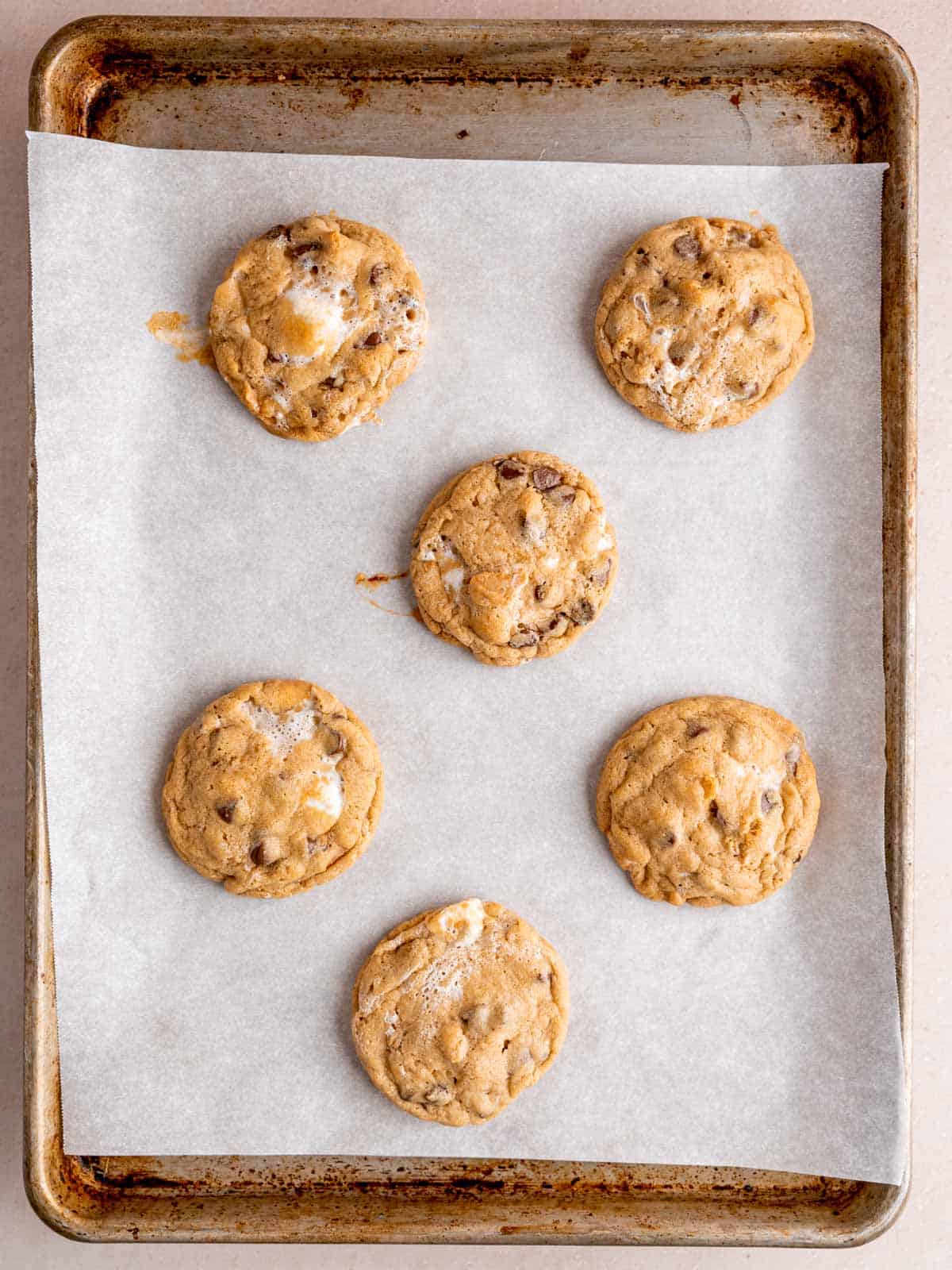Baked s'mores cookies on a parchment lined baking pan.