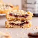 Two halves of a raspberry crumble cookie stacked on top of each other.