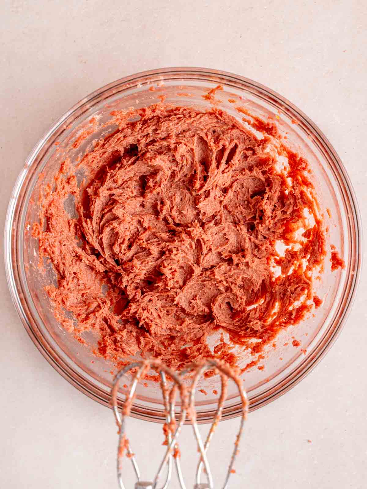 Butter, granulated sugar, strawberry powder, and strawberry jam mixed together in a bowl.