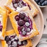 Blueberry cheese puff pastries dusted with powdered sugar.