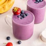 Two banana berry protein smoothies in clear glass cups.