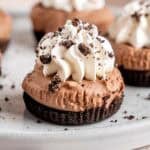 No-bake mini chocolate cheesecakes topped with whipped cream and crushed Oreo cookies.