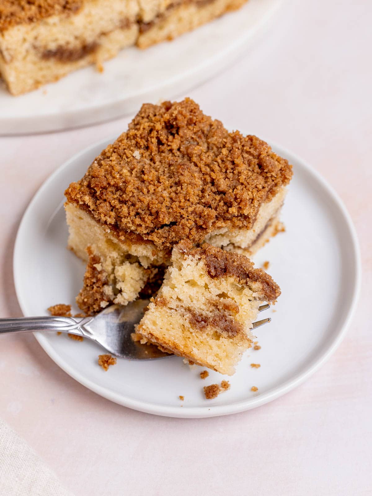 A fork cutting a bite out of a slice of sourdough coffee cake.