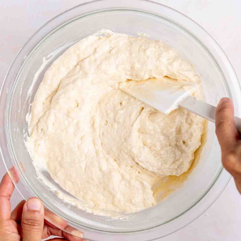Folding dry ingredients into sourdough coffee cake wet ingredients.