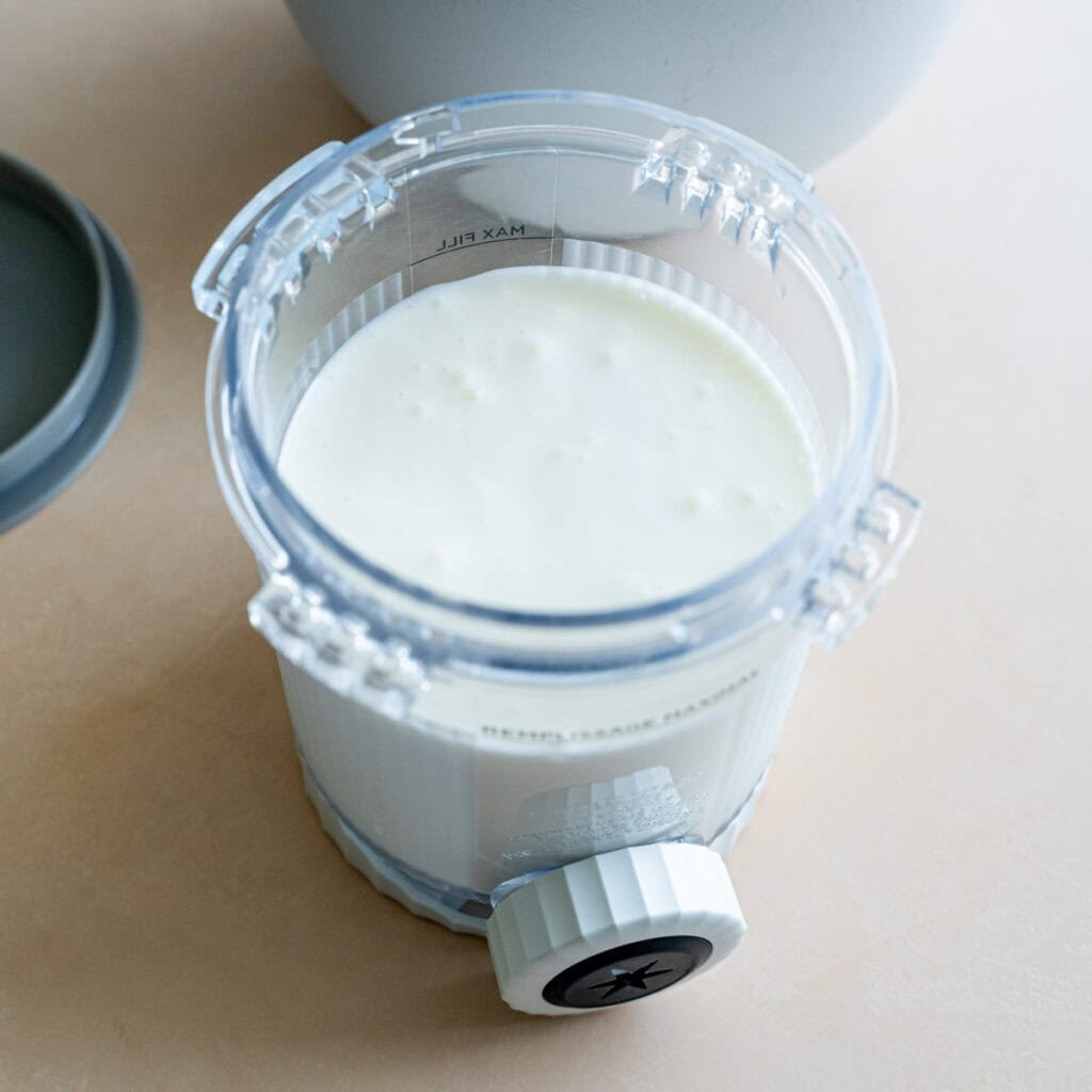 Lemon cheesecake ice cream mixture in a Ninja Creami pint.