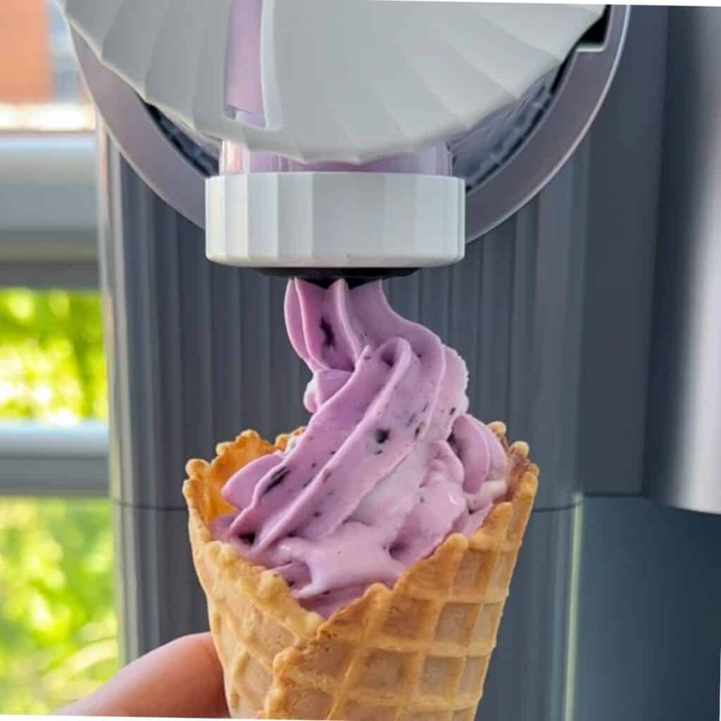 Swirling lemon blueberry cheesecake ice cream out of a Ninja Creami Swirl.