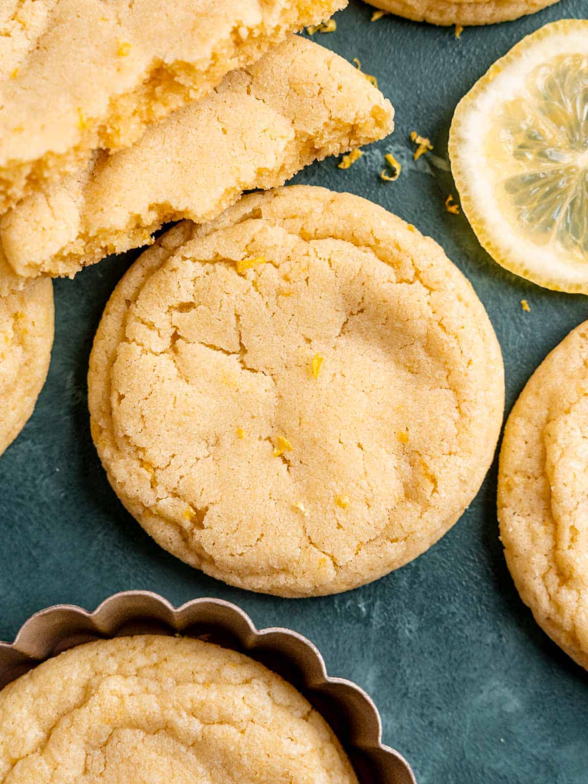 Soft lemon sugar cookies with zest and lemon slices.
