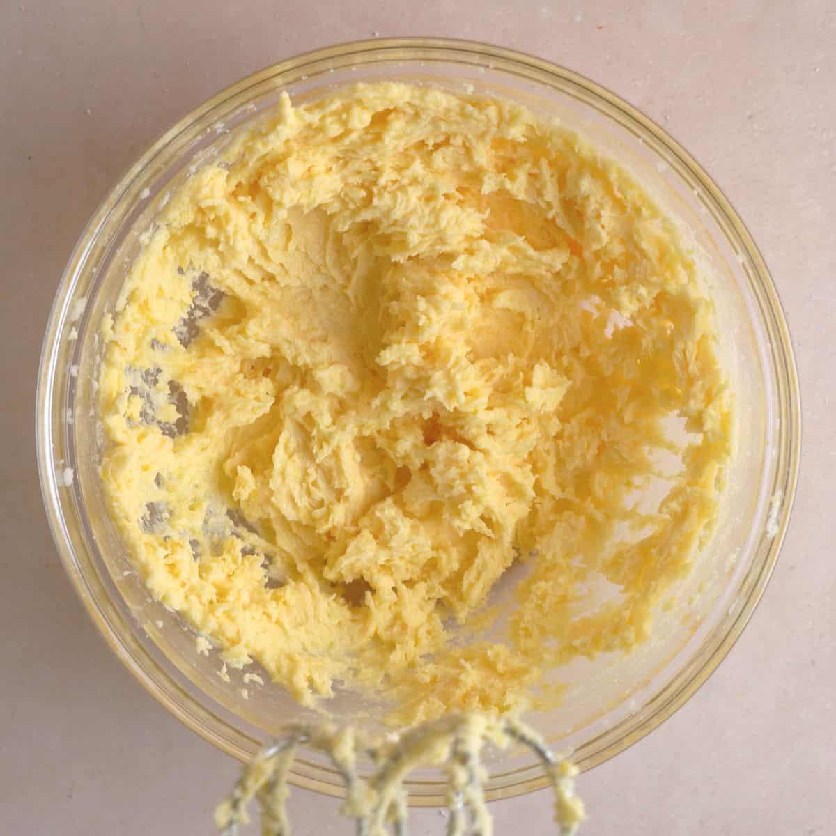 Softened butter, lemon sugar, egg yolk, lemon juice, and vanilla extract creamed together in bowl.