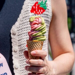 Kayla Burton holding strawberry matcha ice cream in a sugar cone.