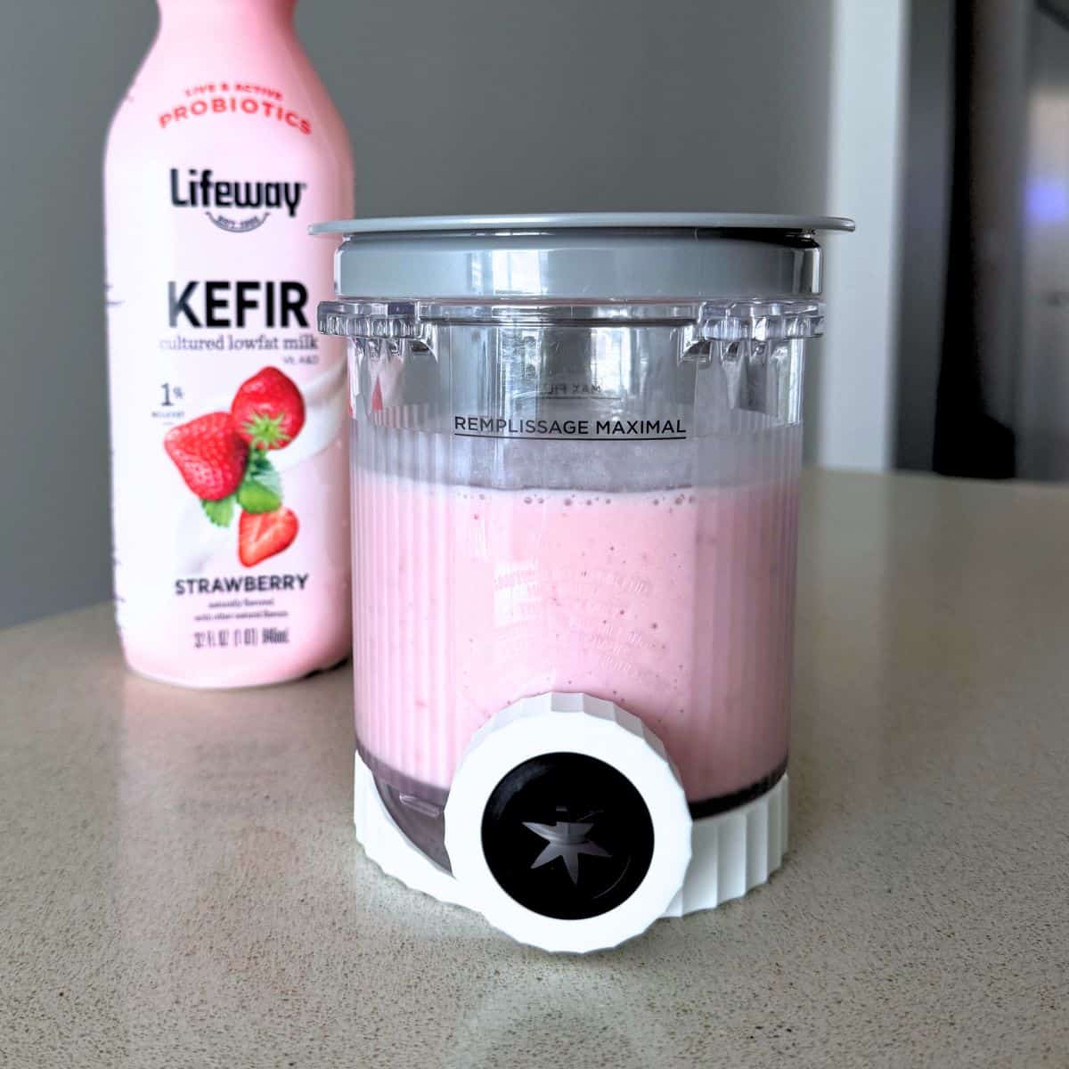 A mixture of strawberries, sugar, and Lifeway strawberry kefir in a Ninja Creami pint.