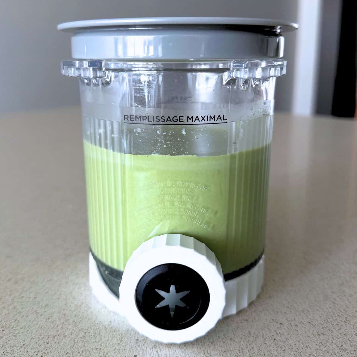 A mixture of milk, matcha, sugar, and heavy cream in a Ninja Creami Swirl pint.