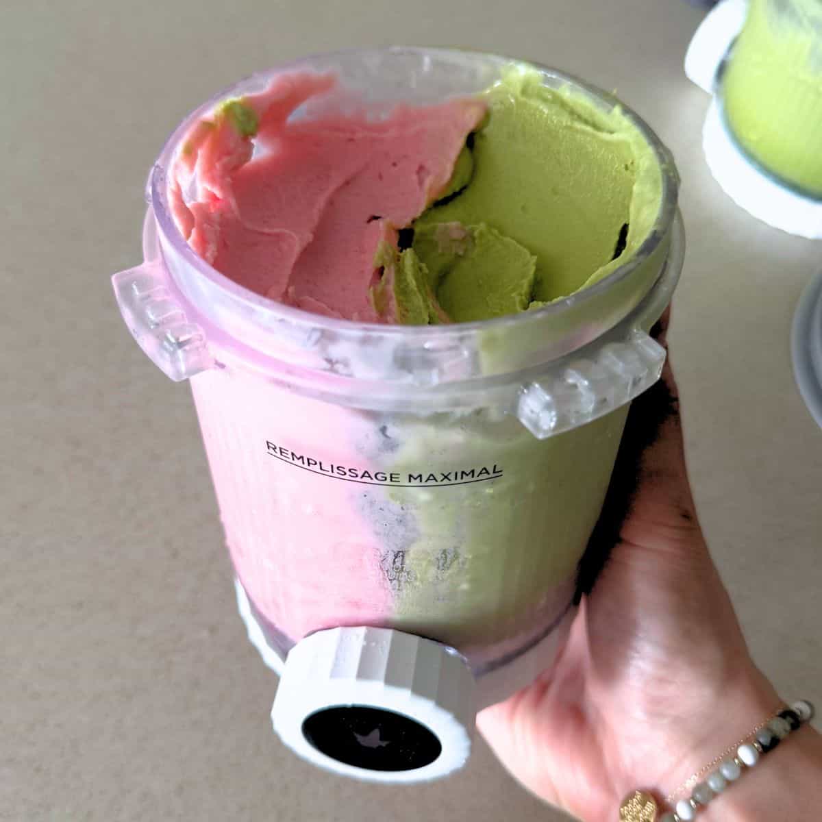A Ninja Creami Swirl pint filled with half matcha and half strawberry ice cream.