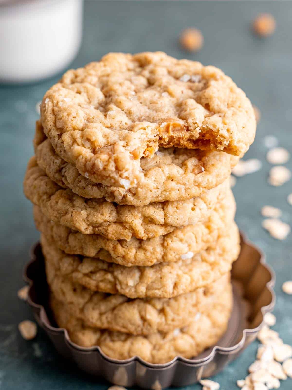A stack of caramel oatmeal cookies with a bite taken out of one.