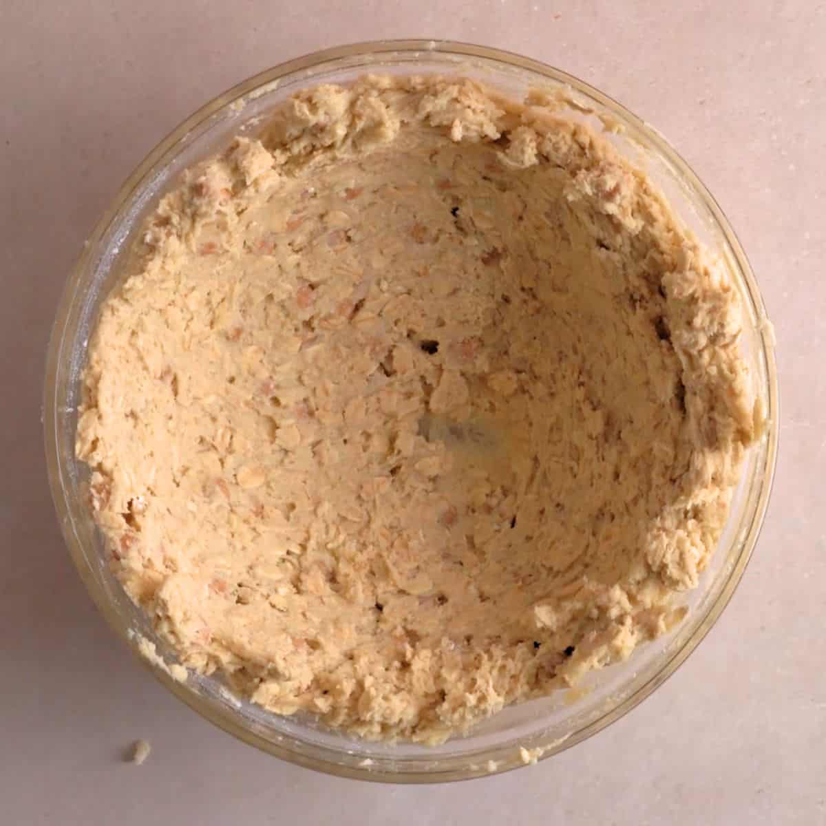 Caramel oatmeal cookie dough pressed against the sides of a bowl.
