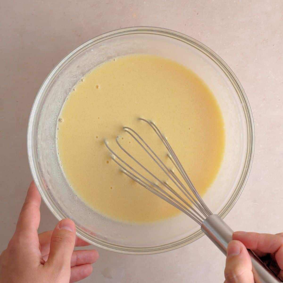 Whisking eggs, kefir, vegetable oil, and vanilla extract in a bowl.