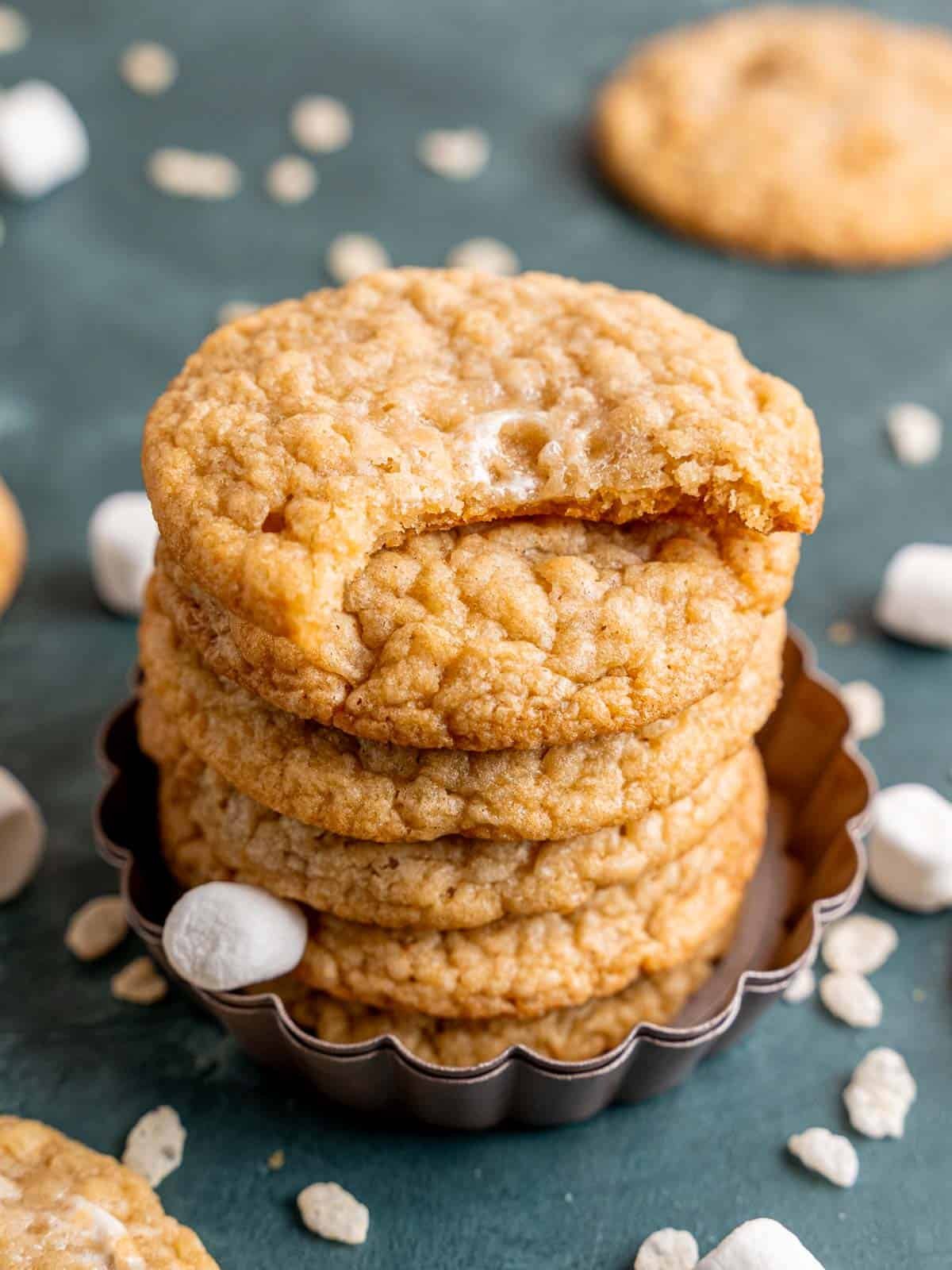 Marshmallow crispy cookies stacked with a bite taken out of one.