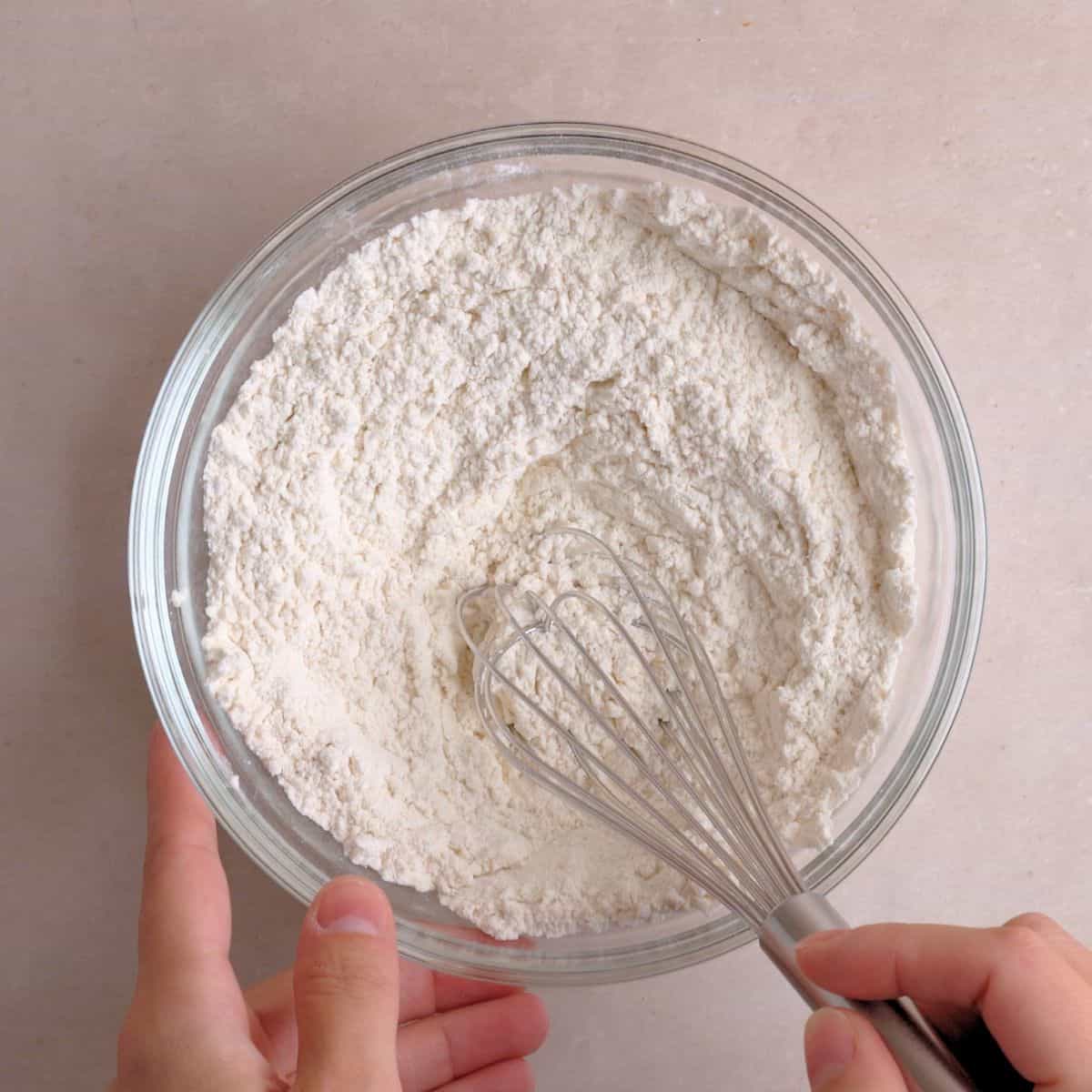 Flour, baking powder, baking soda, and salt whisked in a bowl.