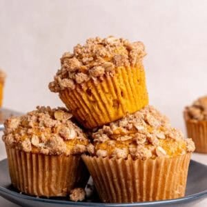 A stack of pumpkin oatmeal muffins on a plate.