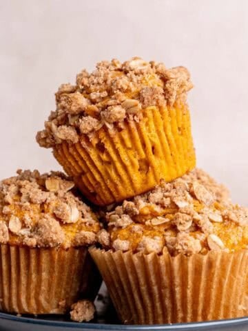 A stack of pumpkin oatmeal muffins on a plate.