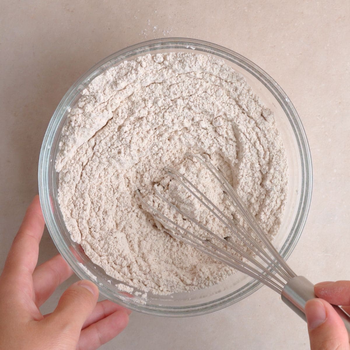 Flour, baking powder, baking soda, salt, cinnamon, nutmeg, and ginger whisked together in a bowl.