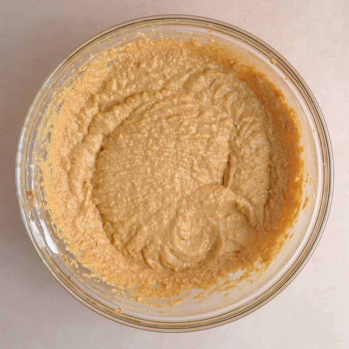 Softened butter, brown sugar, eggs, vanilla extract, sour cream, and molasses creamed together in a bowl.