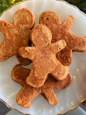 Gingerbread man pancakes on a plate.