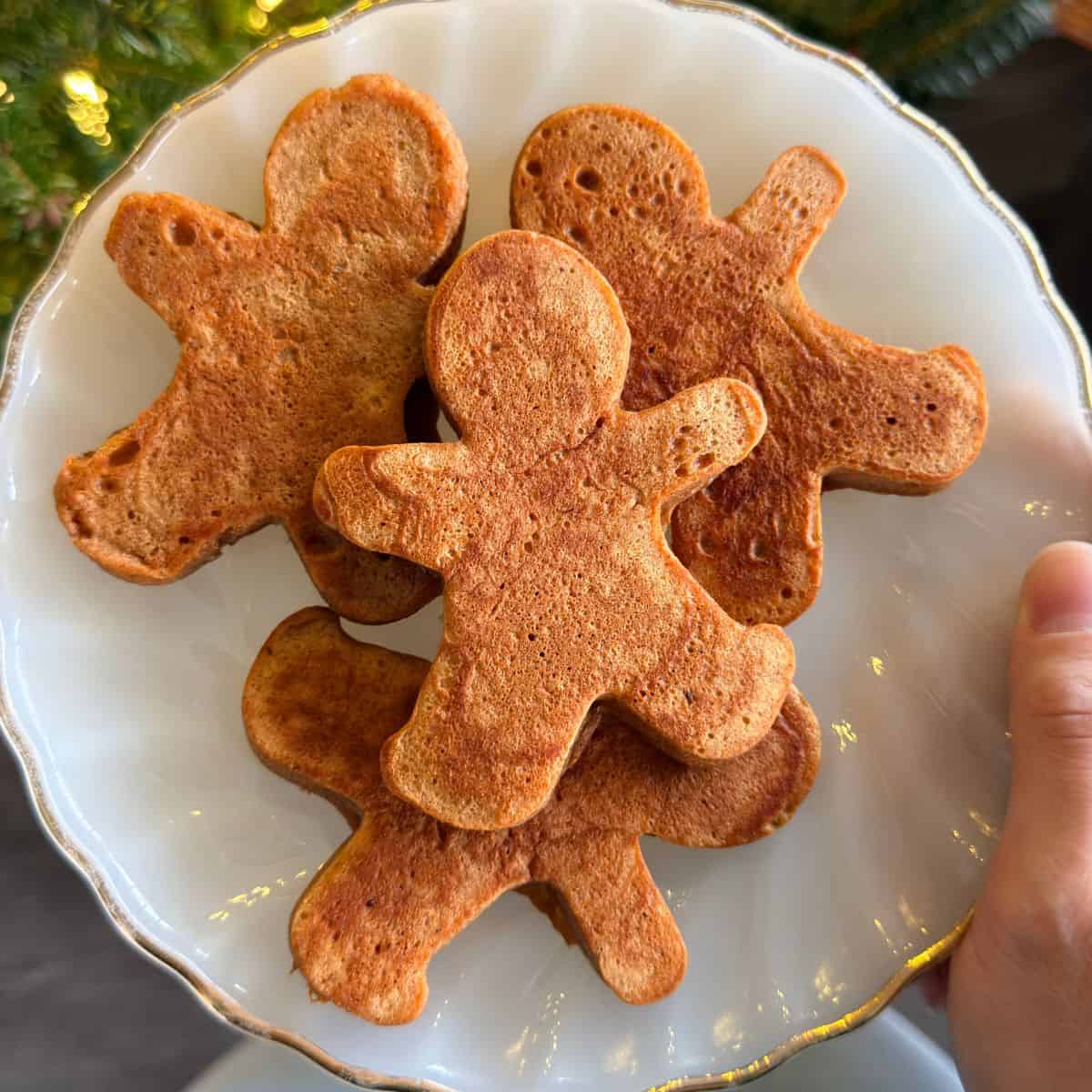 Gingerbread man pancakes on a plate.