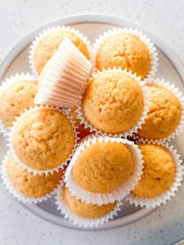 Mini honey muffins stacked on a plate.