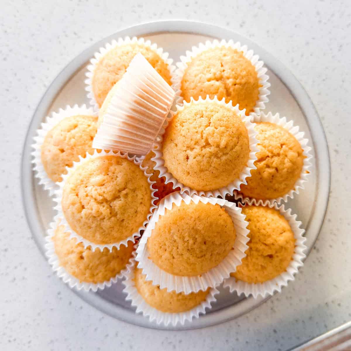 Mini honey muffins stacked on a plate.