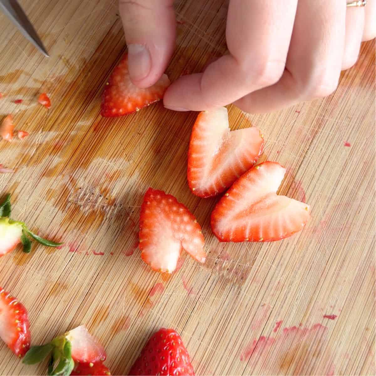Cutting strawberries into thin slices.
