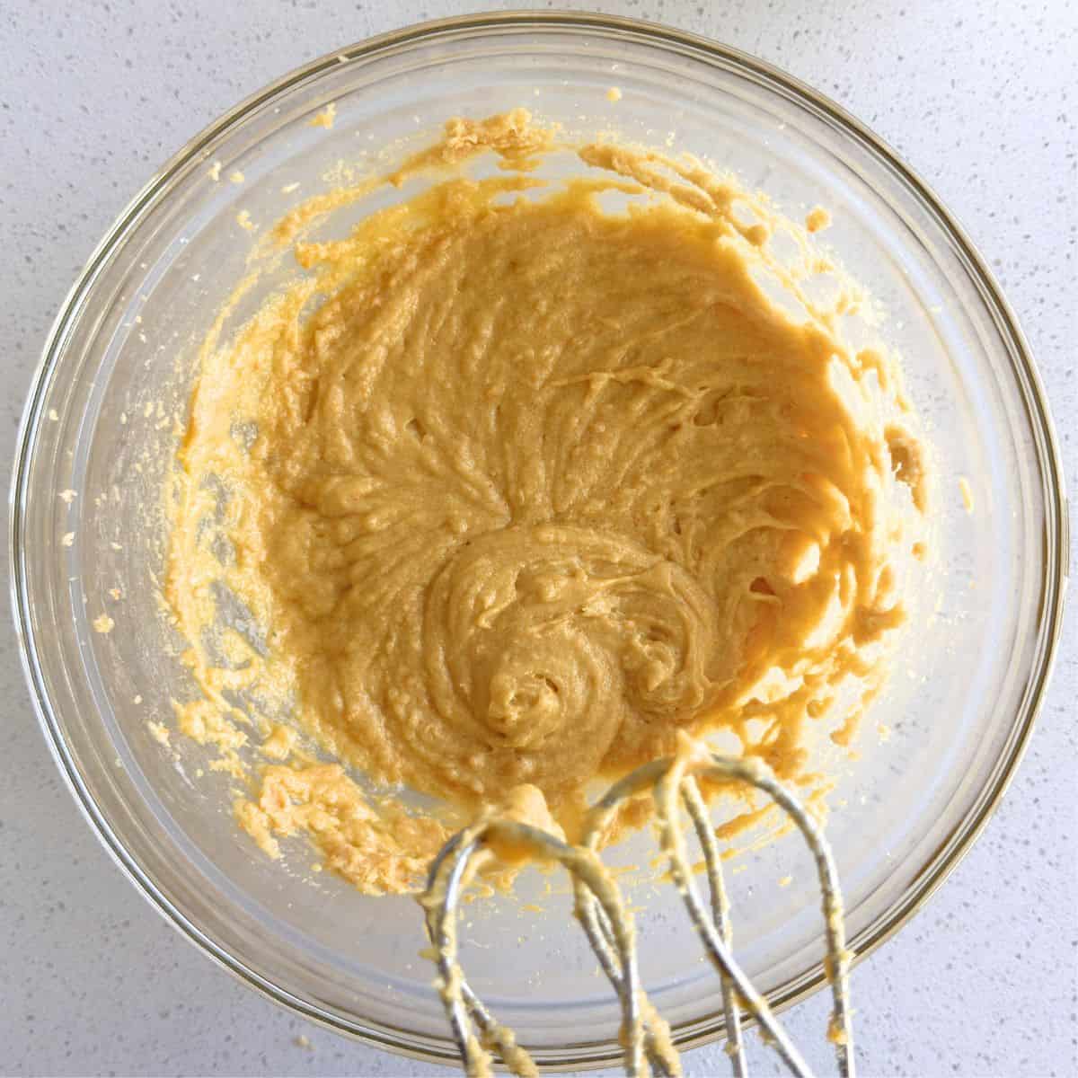 Softened butter, brown sugar, orange sugar, egg, vanilla extract, and almond extract mixed together in a bowl.